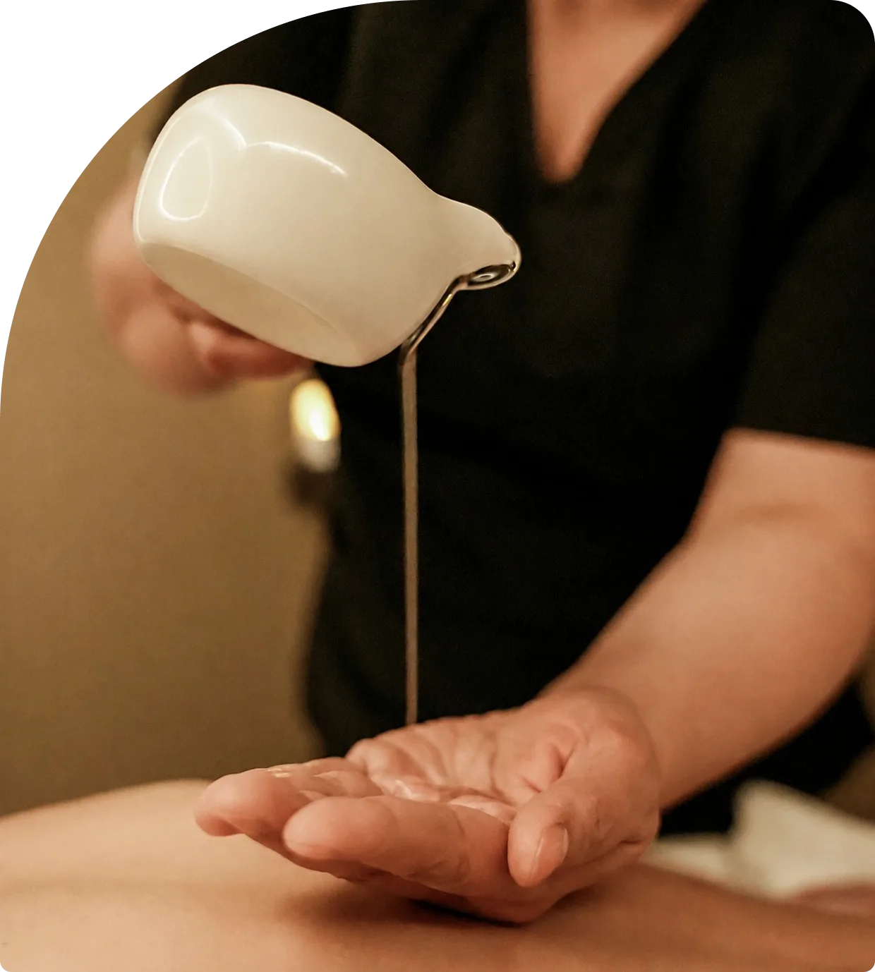 Terapeutka Magic Bali Spa nalewa ciepły olejek do masażu
