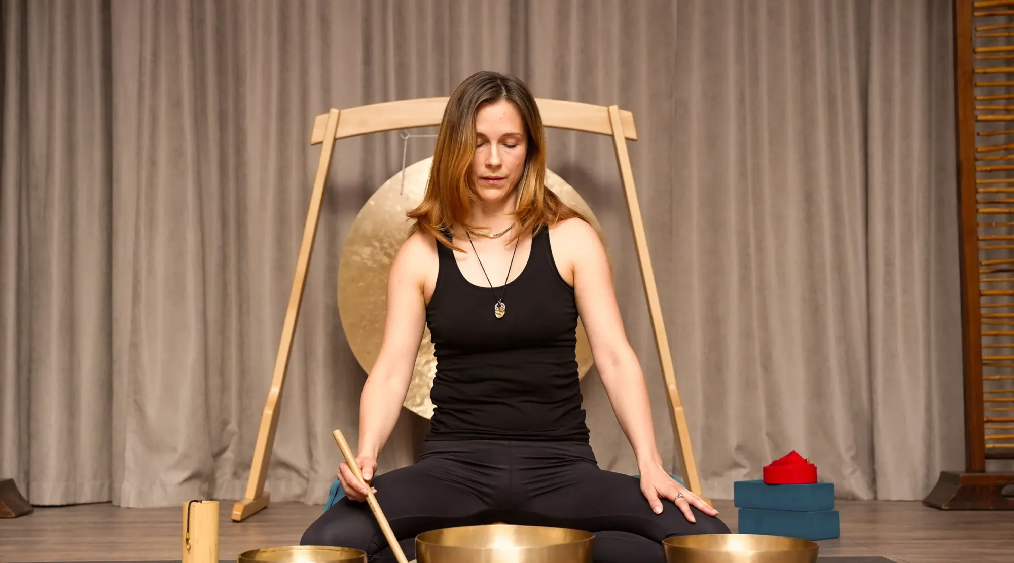 A yoga teacher with Tibetan singing bowls in the Magic Bali Spa yoga room